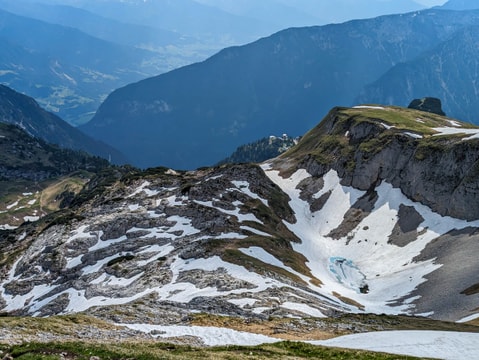 Small light blue lake formed by a melting snow and ice with huts and Gschöllkopf from Roßkopf descent